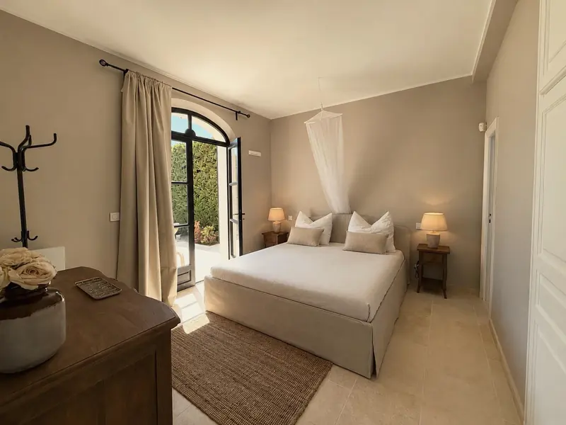Dormitorio con puertas en arco que dan al jardín