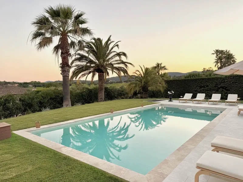 Palmeras reflejadas en la piscina al atardecer