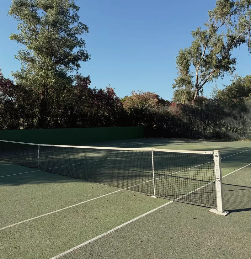 La pista de tenis de la urbanización, rodeada de eucaliptos